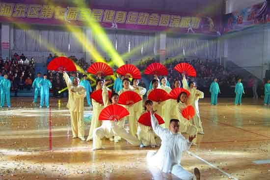 天津市河东区第七届全运会开幕式 袁均 2013.4.24 天津市第四届《体彩杯》全民健身运动会系列活动暨河东区第七届全民健身运动会于2013年4月23日下午在第102中学文体馆举行,我们中山门互助西里众望谊康健身队选拔了十几名优秀队员参加河东区太极拳协会综合拳术表演节目,在全场第五个节目演出。共有四个队同时分别表演太极拳、剑、刀、扇,我们队参演的是新改编的太极功夫扇,为了准备这个节目,队员们克服各种困难,排练了一个多月,采用统一的音乐男儿当自强,威武雄壮,表现了刚柔并济,太极雄风,四个队分别穿著蓝、